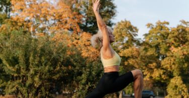 Image of a senior woman practicing yoga in a peaceful outdoor setting: "Senior woman finding relaxation through yoga in nature"