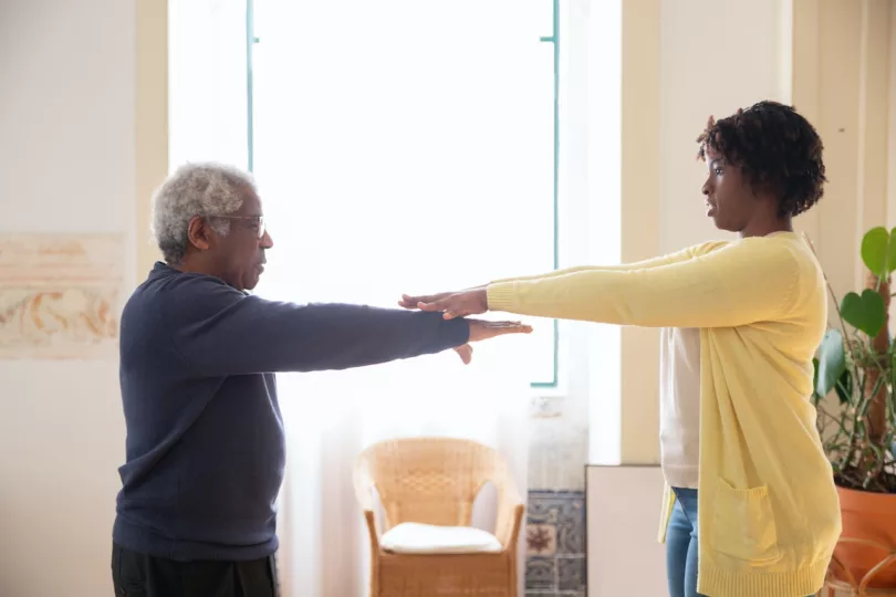 Elderly person doing chair yoga pose to improve flexibility and balance