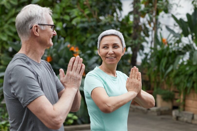 A group of seniors practicing yoga together in a comfortable and safe senior living community setting