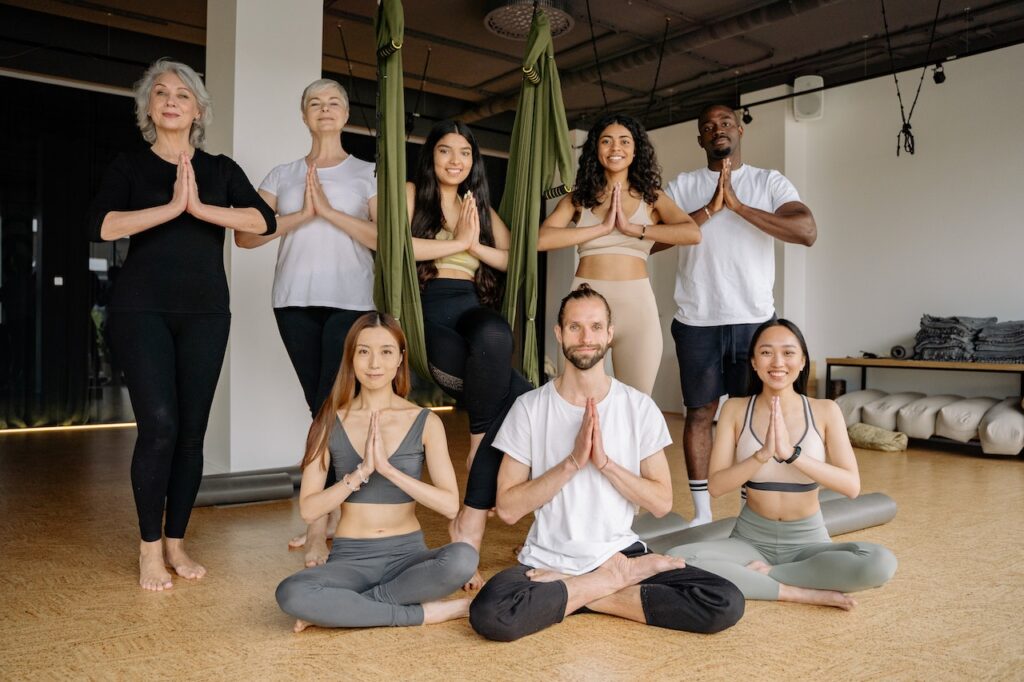 "Instructor assisting a senior student in a yoga pose"